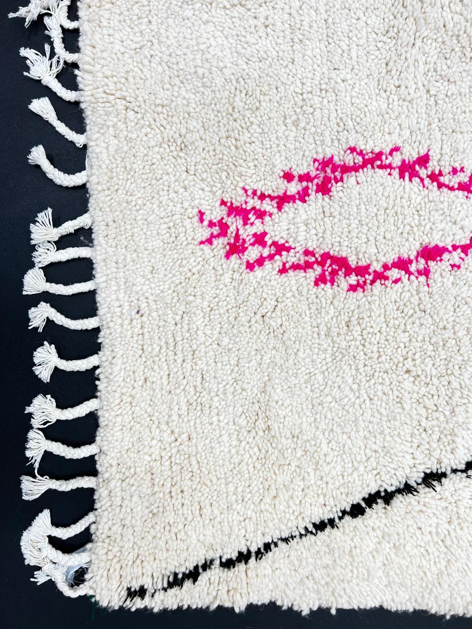 Minimalist Moroccan wool rug with black diamond lines and colorful details on cream background, handmade by Berber artisans