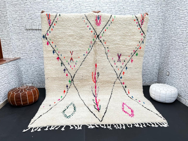 Minimalist Moroccan wool rug with black diamond lines and colorful details on cream background, handmade by Berber artisans