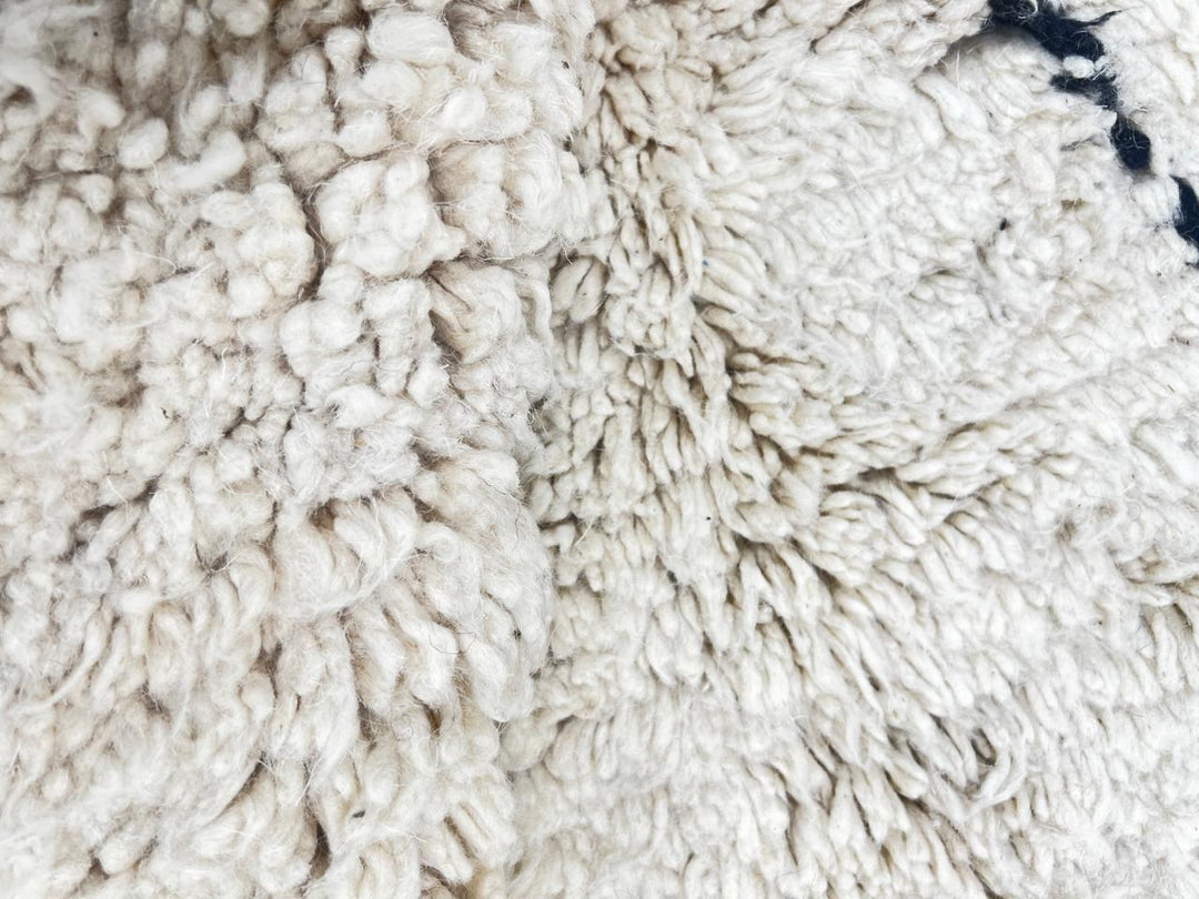 Handmade white Moroccan runner rug with minimalist black geometric line pattern in soft natural wool.