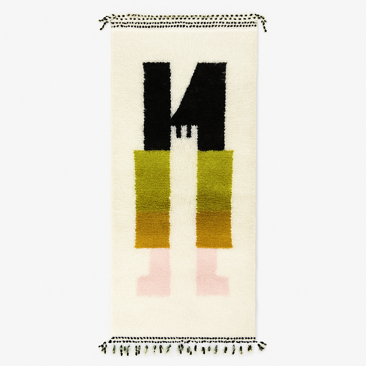 Handmade modern abstract Moroccan wool runner rug with geometric black, green, yellow, and pink design on a white background