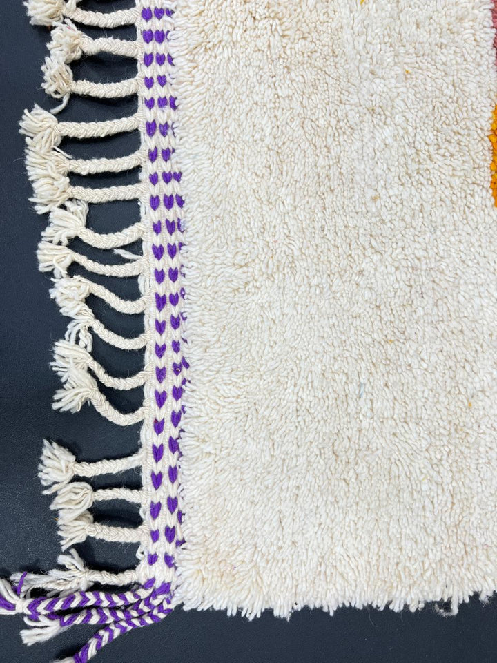Handwoven Moroccan wool rug with modern abstract geometric shapes in purple, orange, and magenta