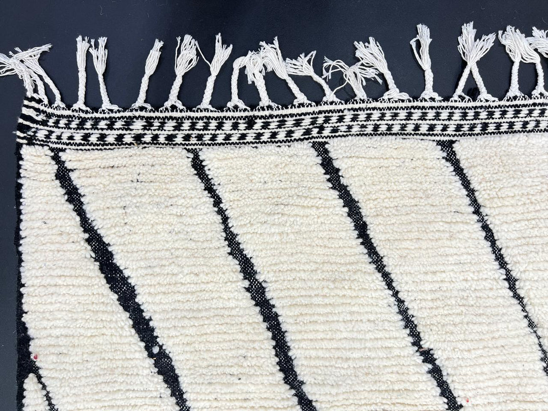 Handwoven Moroccan wool rug with black geometric diamond line pattern