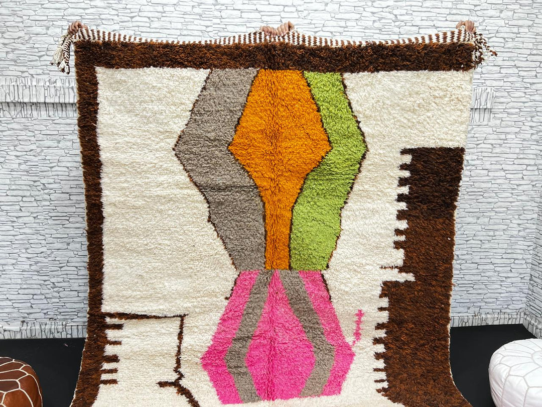Modern Moroccan wool rug with abstract brown, orange, green, and pink geometric patterns, handmade by Berber artisans