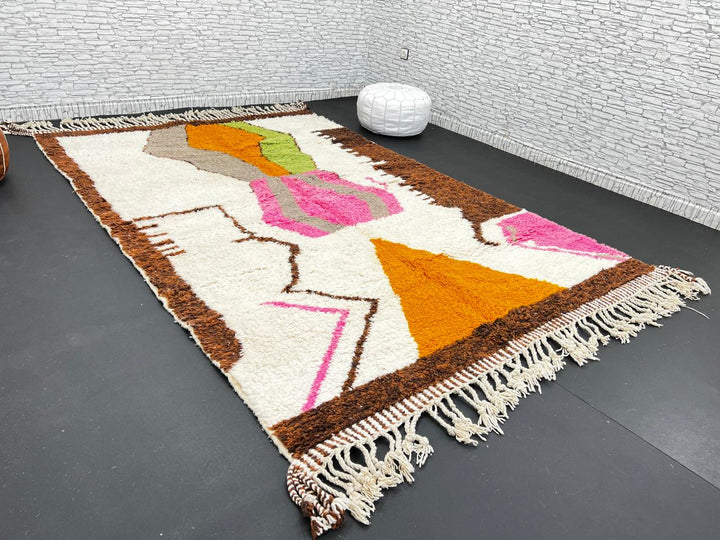 Modern Moroccan wool rug with abstract brown, orange, green, and pink geometric patterns, handmade by Berber artisans
