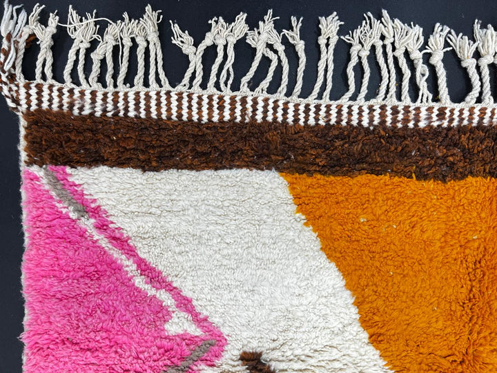 Modern Moroccan wool rug with abstract brown, orange, green, and pink geometric patterns, handmade by Berber artisans