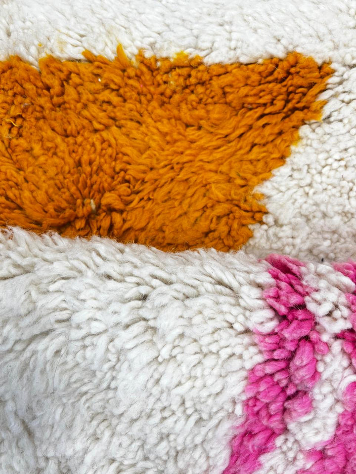 Modern Moroccan wool rug with abstract brown, orange, green, and pink geometric patterns, handmade by Berber artisans