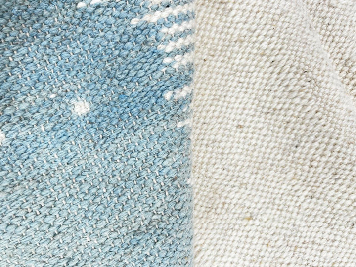 Flat weave round Moroccan wool rug with modern abstract design in terracotta, ivory, and soft blue tones