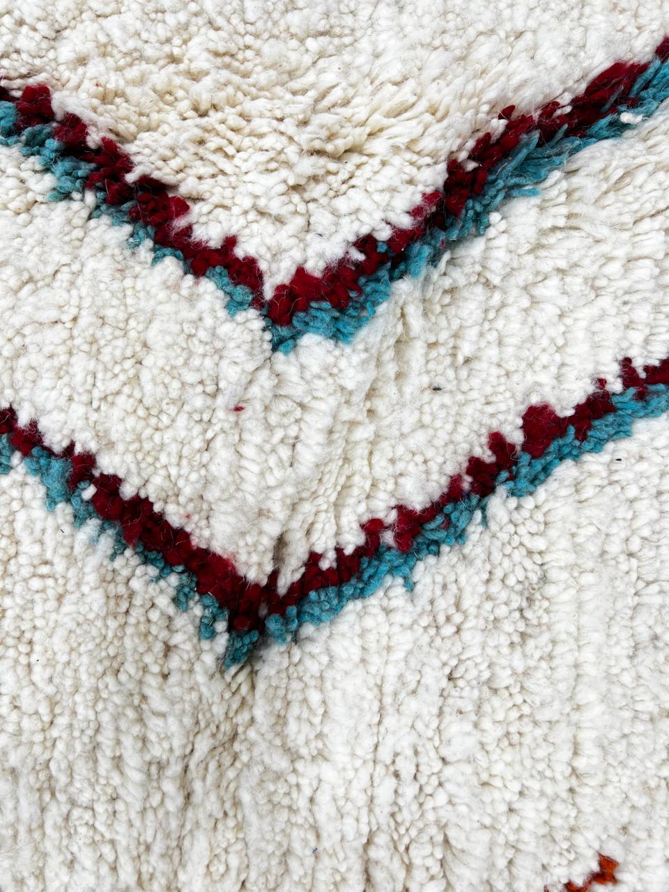 Handmade Moroccan Berber round rug with colorful geometric diamond patterns on an white wool background