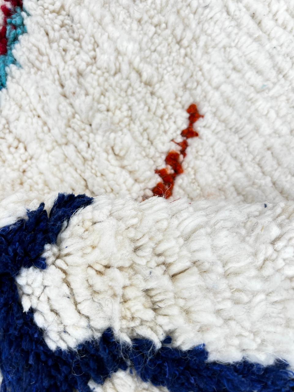 Handmade Moroccan Berber round rug with colorful geometric diamond patterns on an white wool background