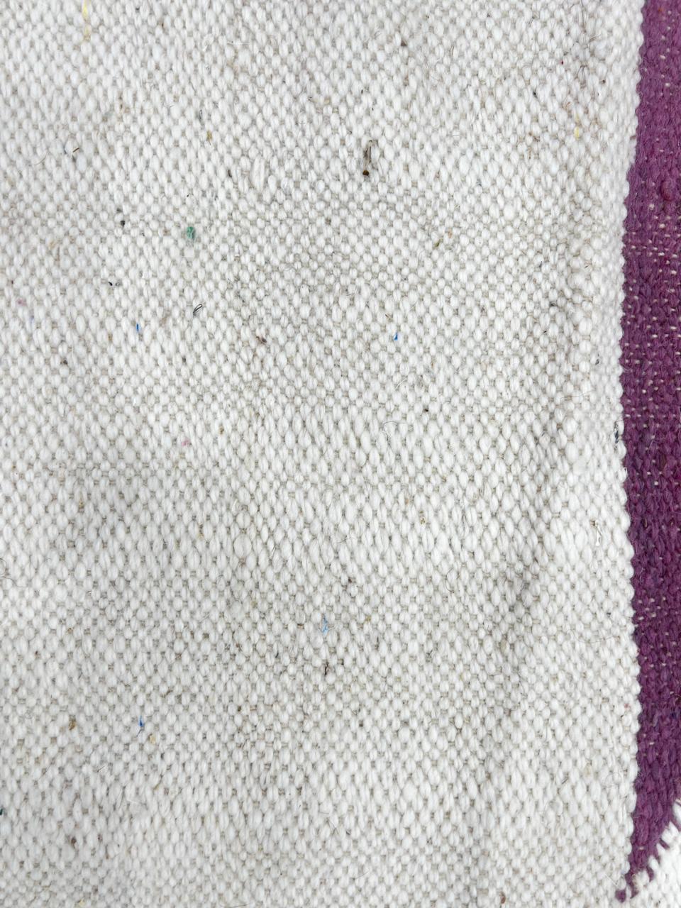 Handwoven Moroccan kilim runner rug with minimalist blush pink and plum geometric pattern on white flatweave wool background.