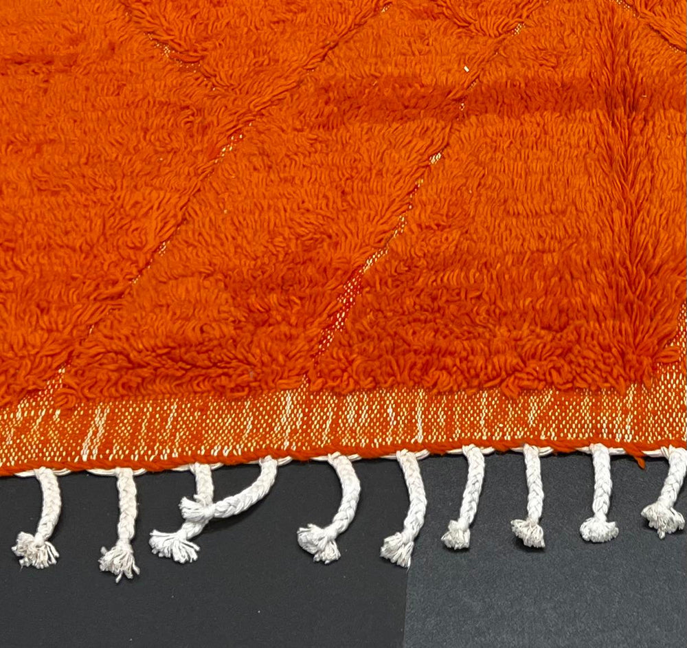 Handmade orange Moroccan runner rug with shag wool texture and diamond geometric pattern, crafted by Berber artisans.