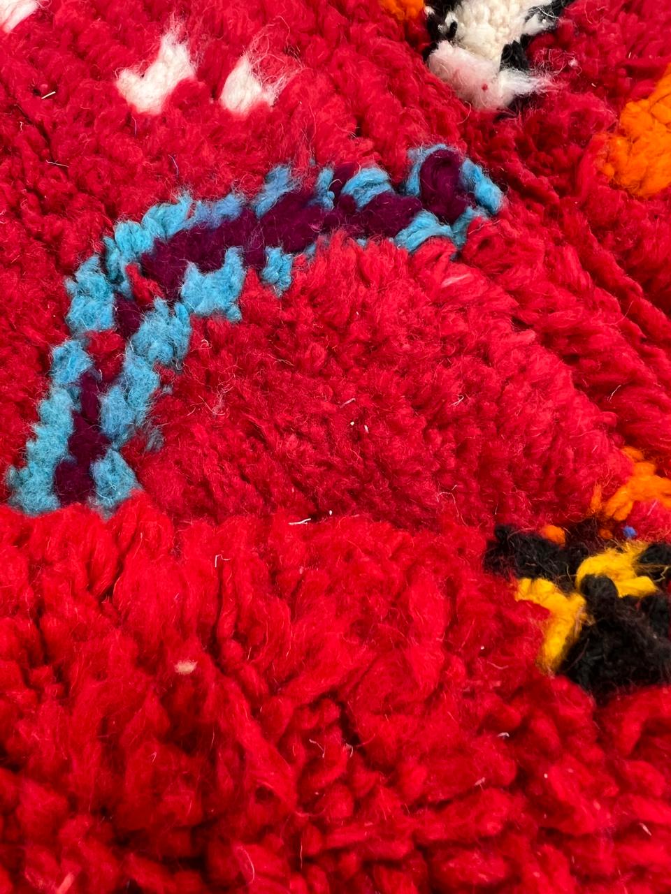 Handwoven red Moroccan wool runner rug with colorful Berber tribal patterns