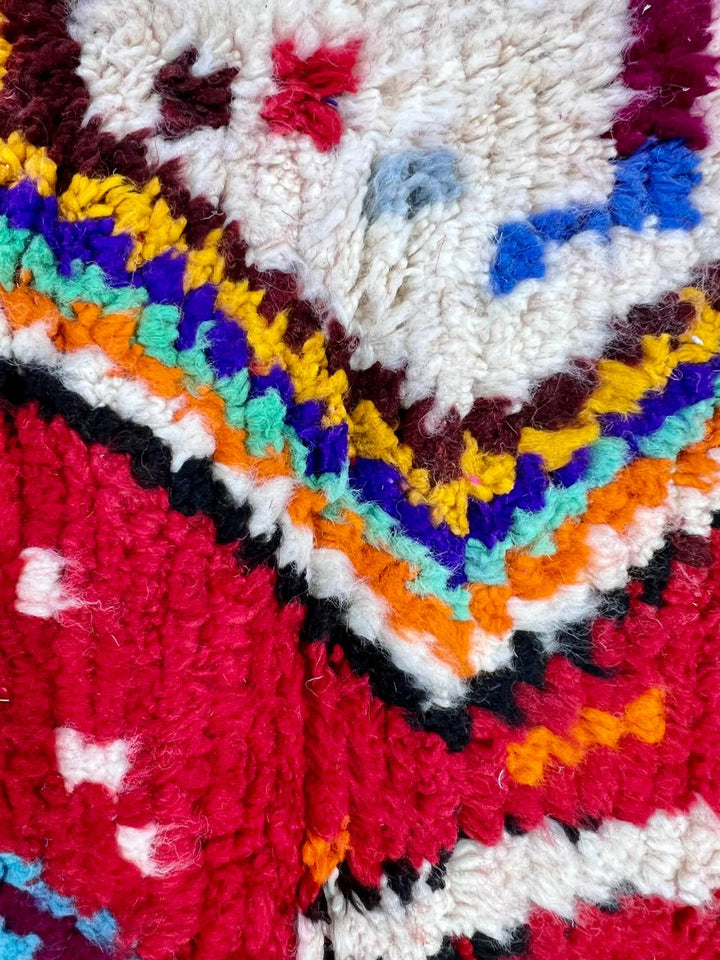 Handwoven red Moroccan wool runner rug with colorful Berber tribal patterns