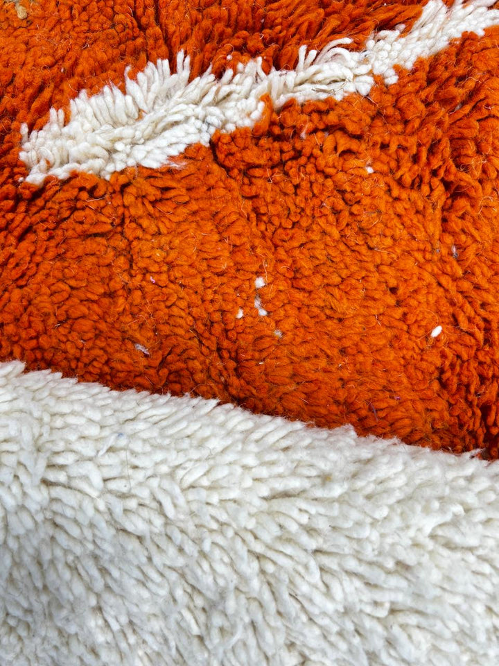 Round abstract Moroccan wool rug with blue, orange, green, and white modern design