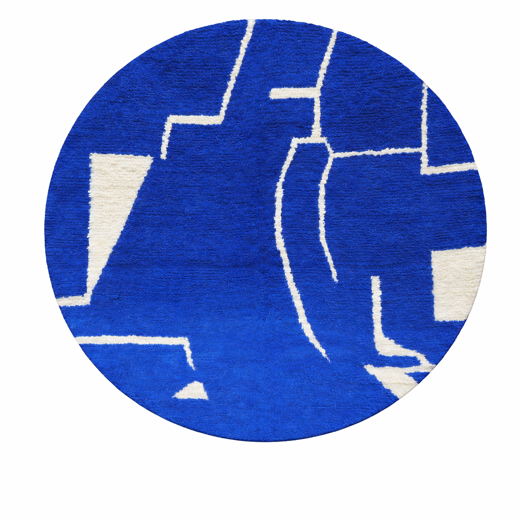 Round handmade Moroccan wool rug featuring a rich cobalt blue background with abstract ivory geometric and linear Berber-inspired patterns.