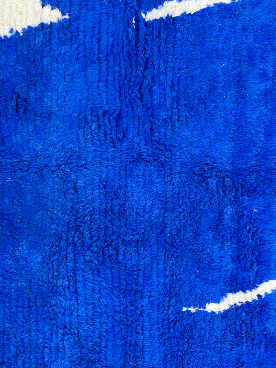 Round handmade Moroccan wool rug featuring a rich cobalt blue background with abstract ivory geometric and linear Berber-inspired patterns.