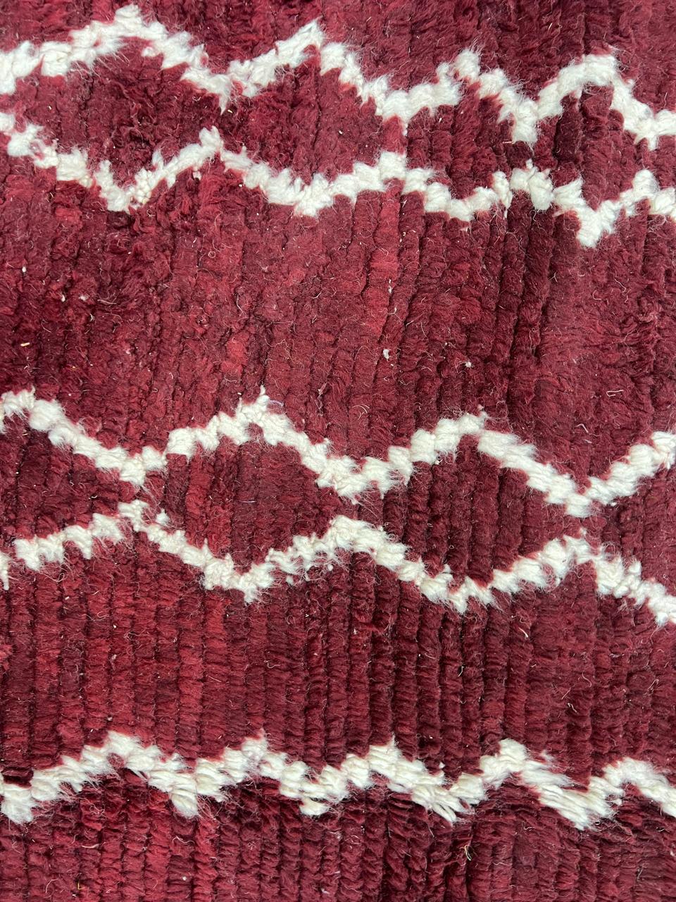 Handmade round Moroccan wool rug in rich burgundy red with ivory Berber geometric patterns, artisan-crafted Amazigh round area rug.