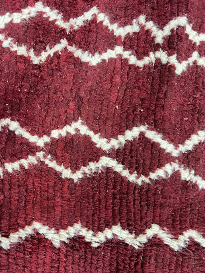 Handmade round Moroccan wool rug in rich burgundy red with ivory Berber geometric patterns, artisan-crafted Amazigh round area rug.