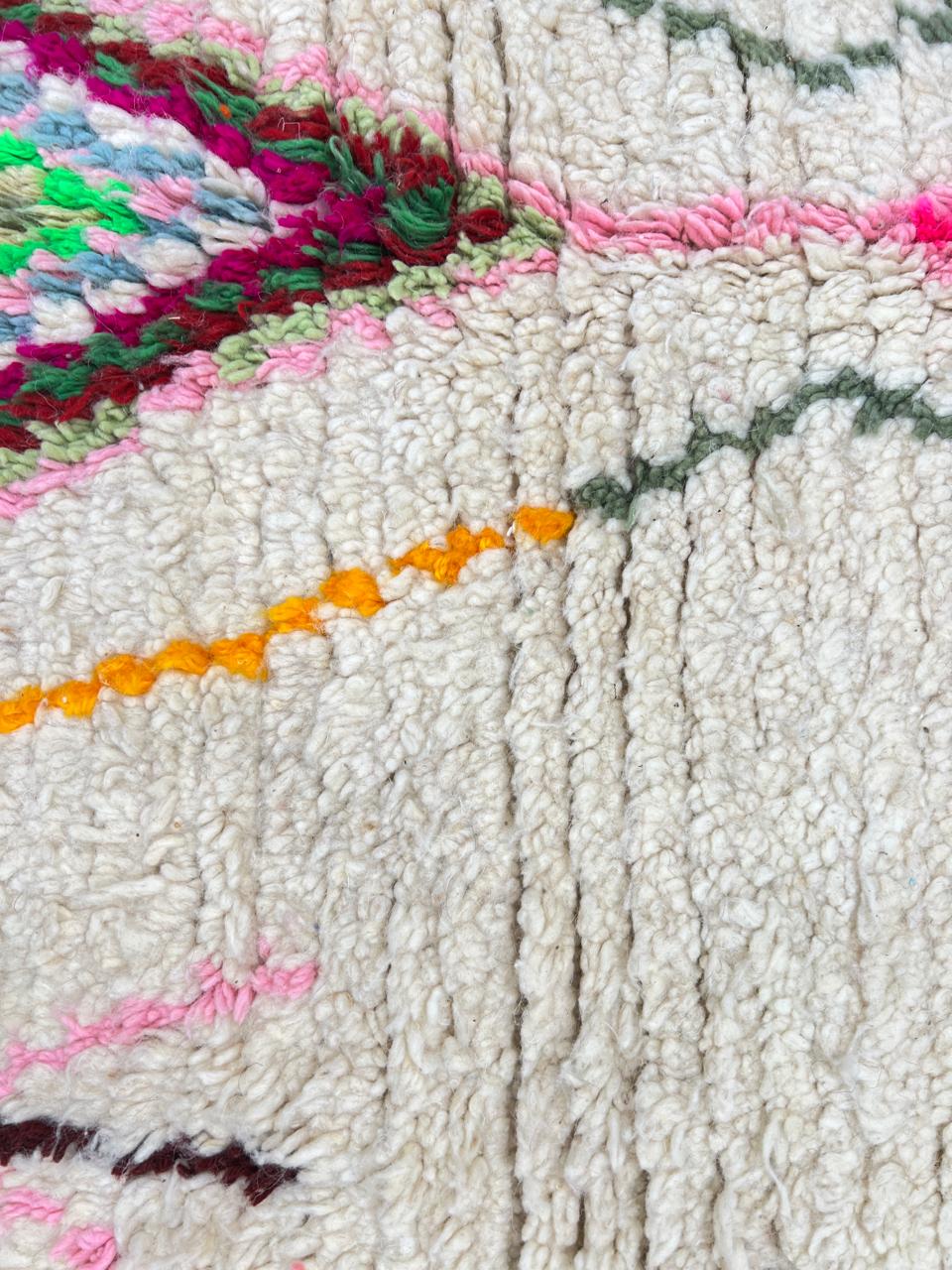 Round white Moroccan wool rug with colorful Berber diamond and arrow patterns