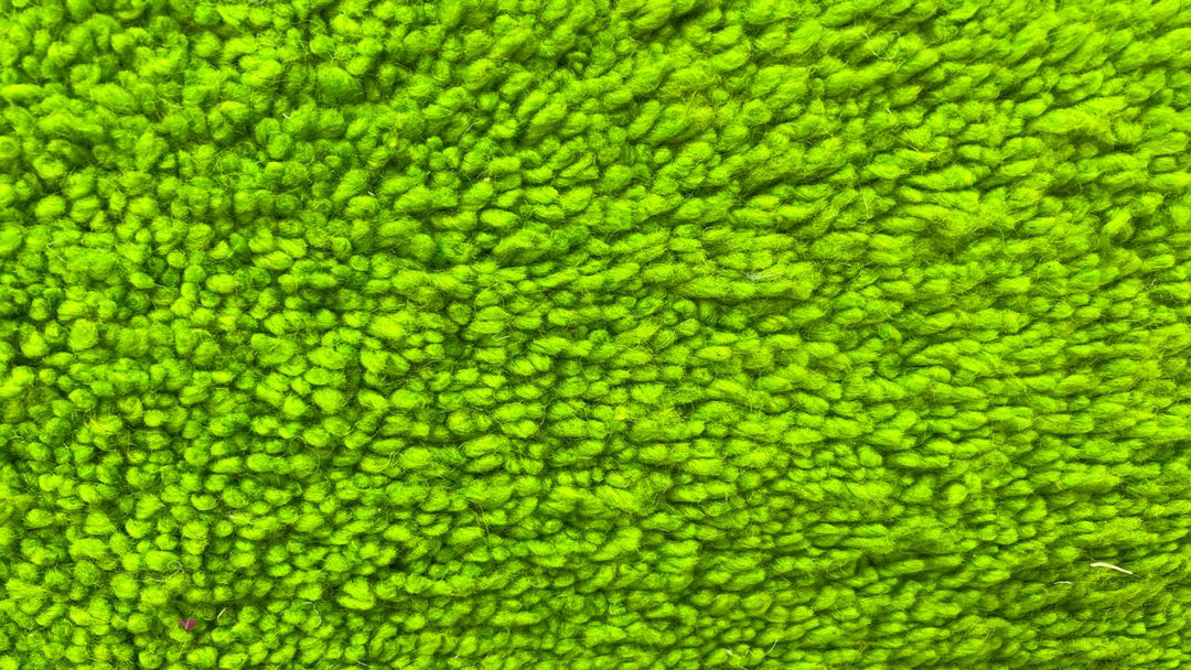 Round handmade Moroccan wool rug in a vibrant green shade, featuring a plush high-pile shag texture and minimalist solid-color design. Circular shape with a soft, cozy surface, perfect for modern
