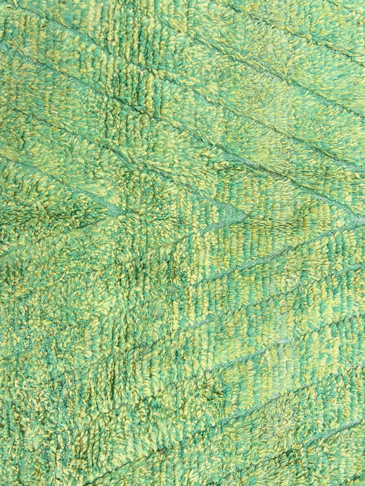 Round handmade Moroccan wool rug in soft sage green tones