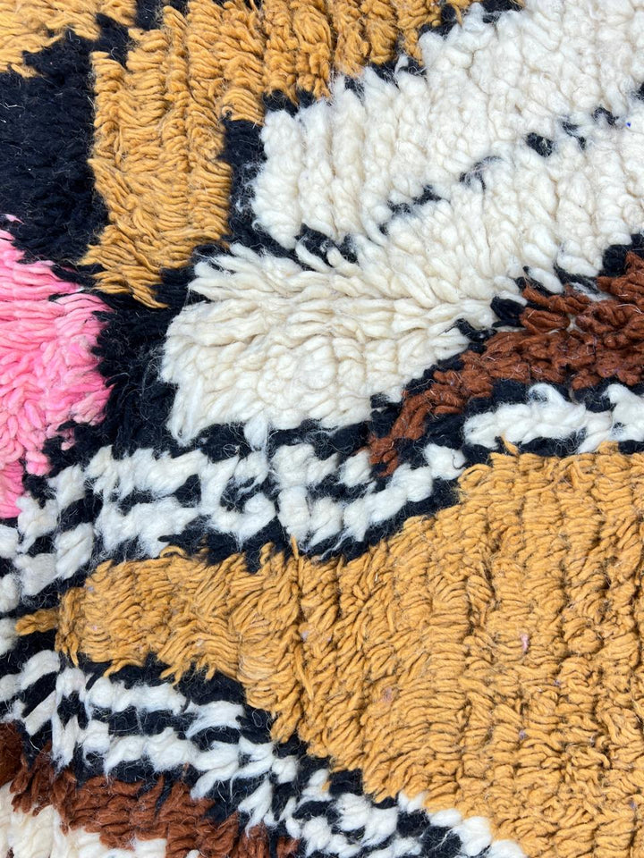 Round Moroccan wool rug with colorful abstract artistic pattern on a cream base