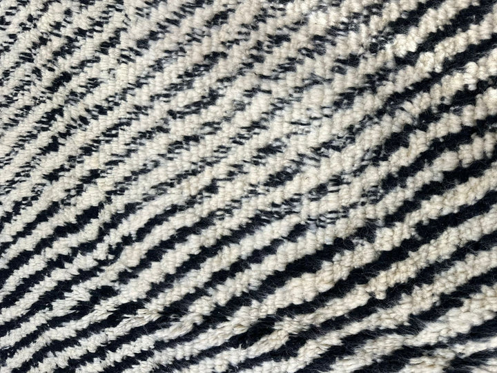 Handmade round Moroccan Berber rug in black and white with symmetrical tribal design