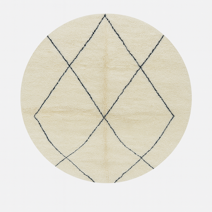 Round Moroccan wool rug in natural ivory with a minimalist black diamond lattice pattern, handwoven in a soft.