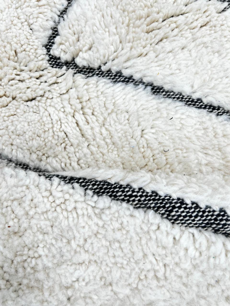 Round handmade Moroccan wool rug with modern carved line pattern, minimalist geometric design.