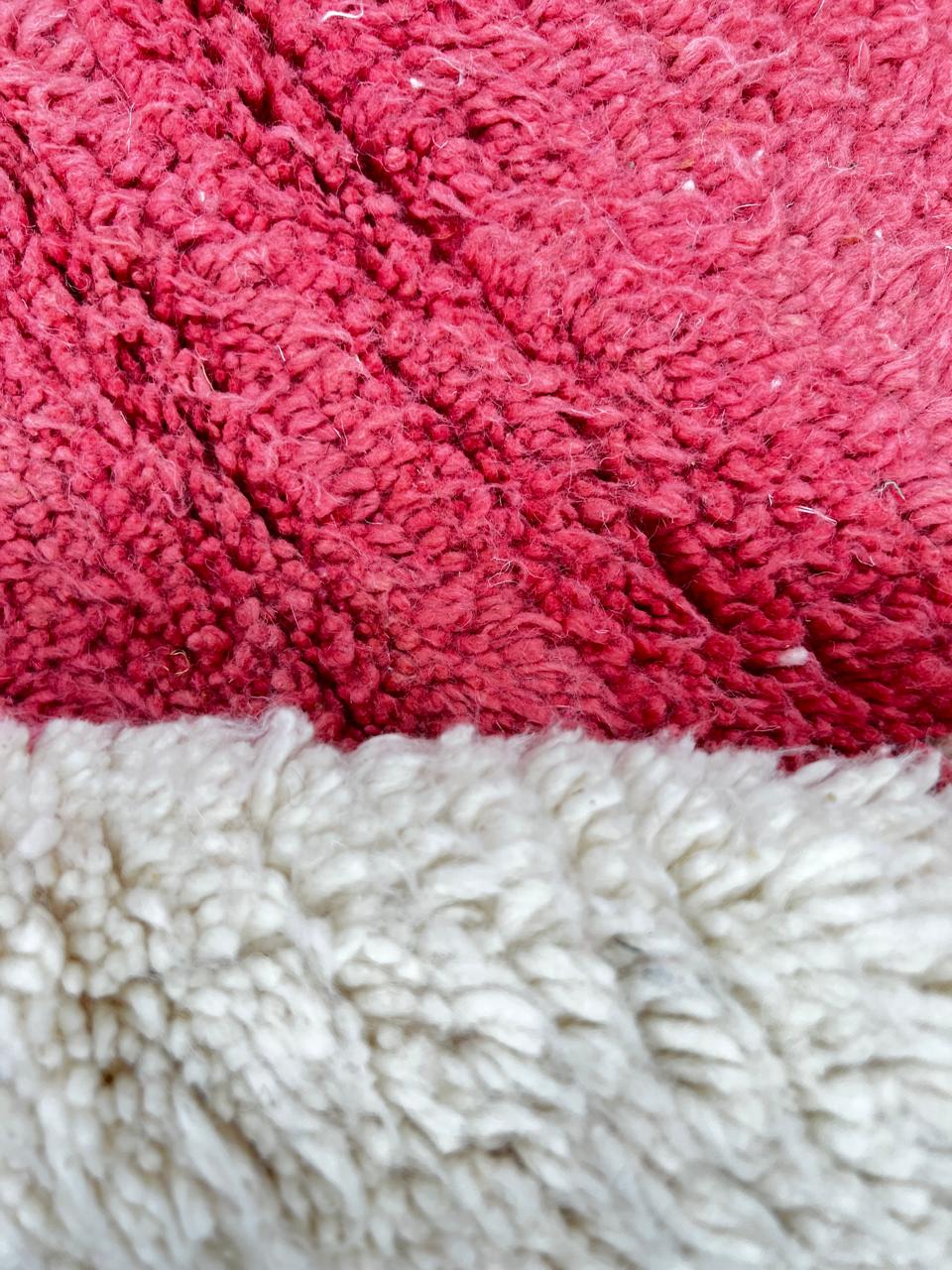 Handmade round Moroccan wool rug with modern geometric design, featuring cream base and bold red, burgundy, purple, orange, and pink color blocks.