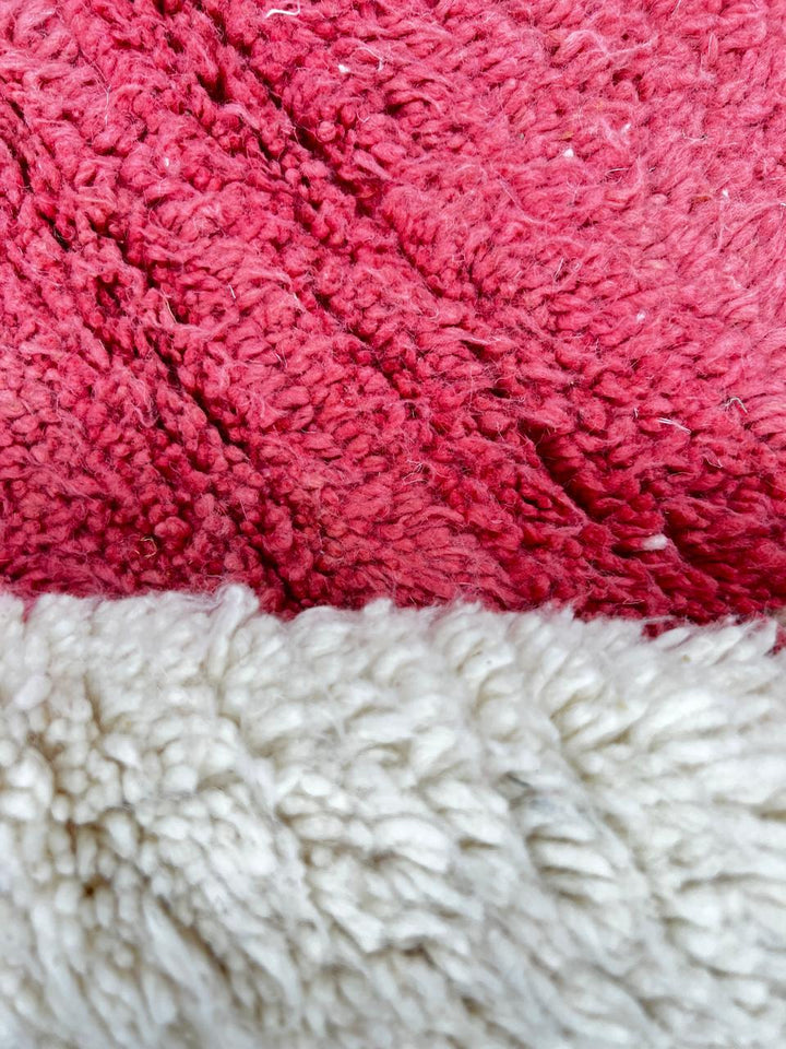 Handmade round Moroccan wool rug with modern geometric design, featuring cream base and bold red, burgundy, purple, orange, and pink color blocks.