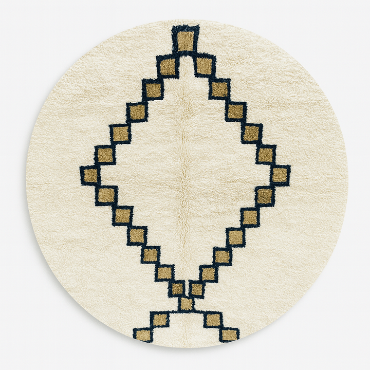 Round ivory Moroccan wool rug with black and tan geometric diamond pattern in a modern neutral living room.