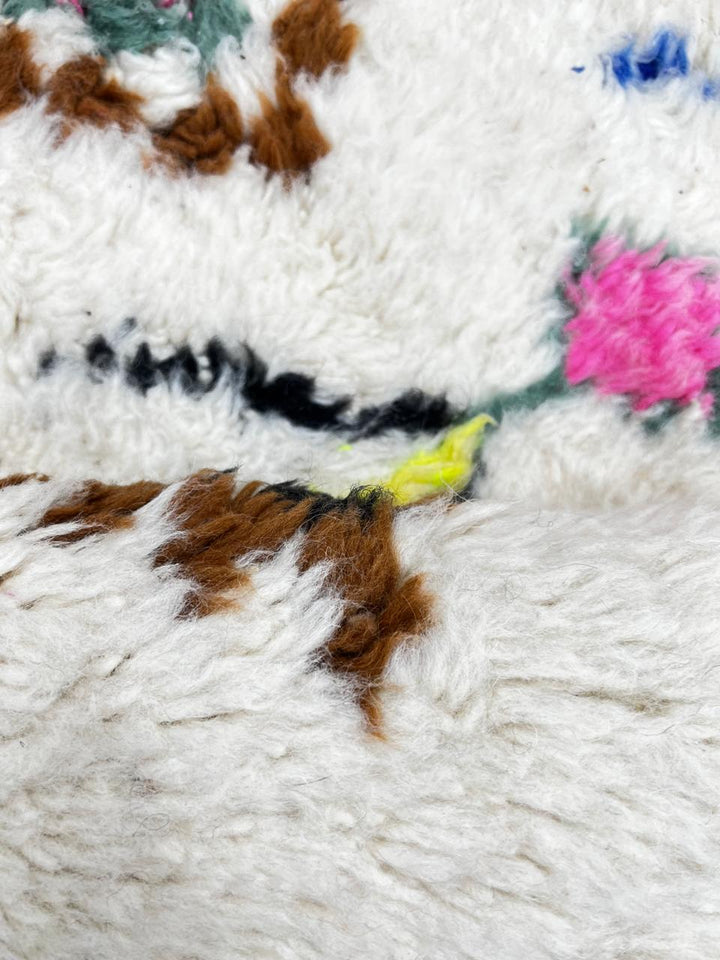 Round Moroccan wool rug with colorful Berber diamond patterns on an white background