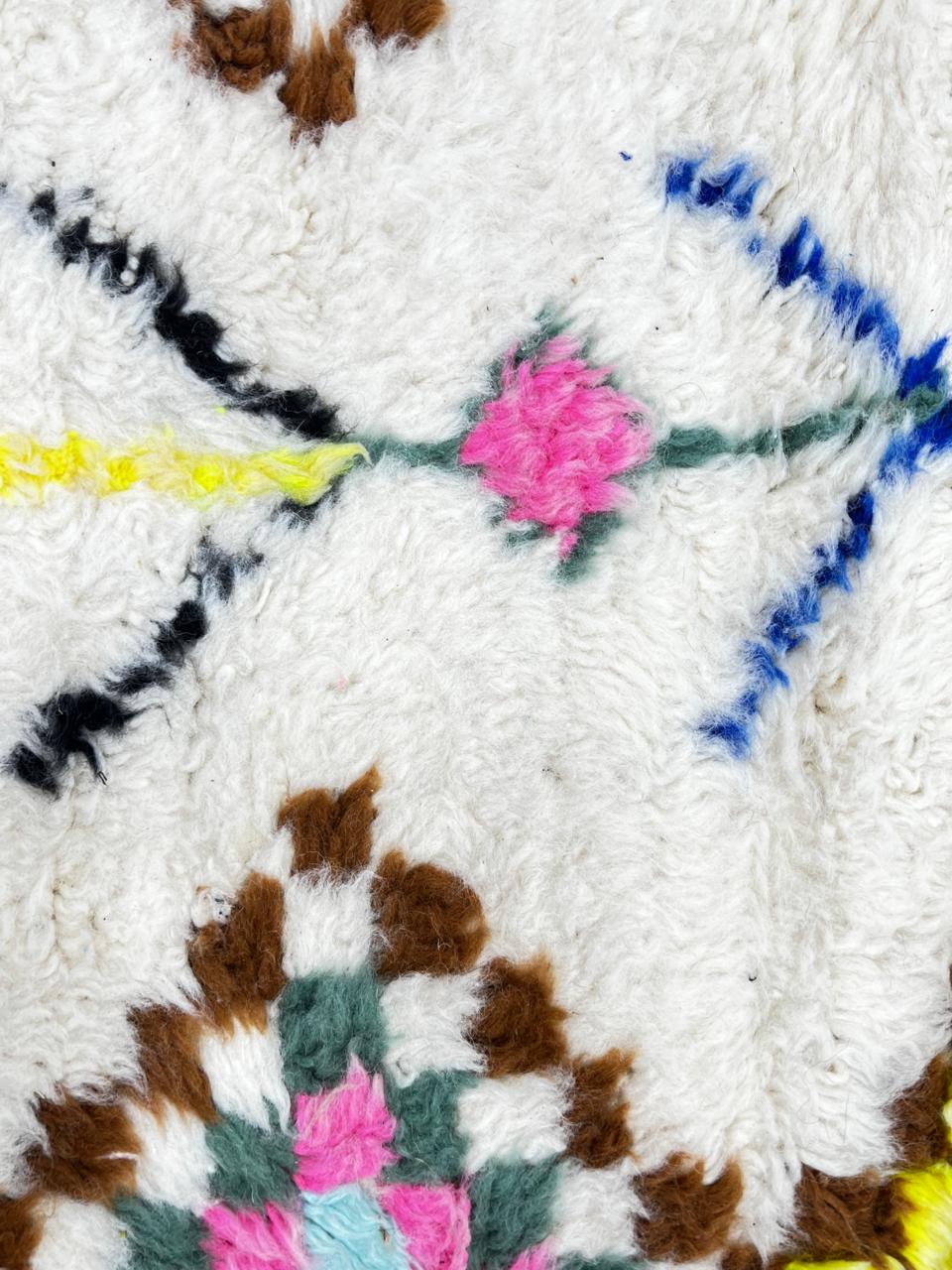Round Moroccan wool rug with colorful Berber diamond patterns on an white background