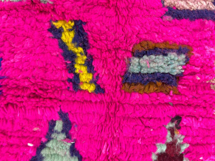 Round pink Moroccan wool rug with colorful Berber geometric patterns