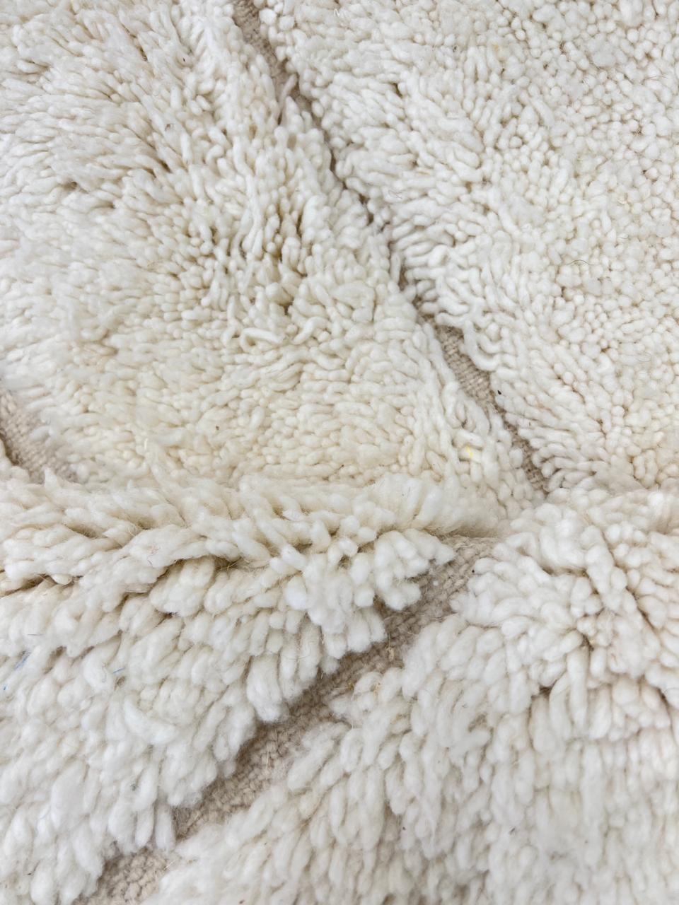 Round white Moroccan wool rug with subtle carved geometric line pattern