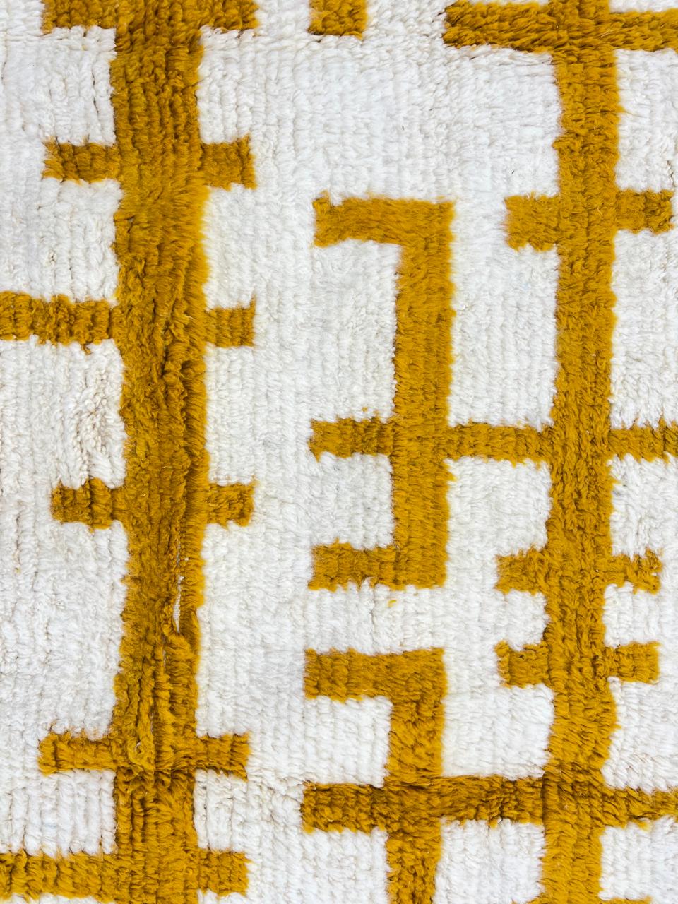 Round handmade Moroccan wool rug in white with mustard Berber pattern
