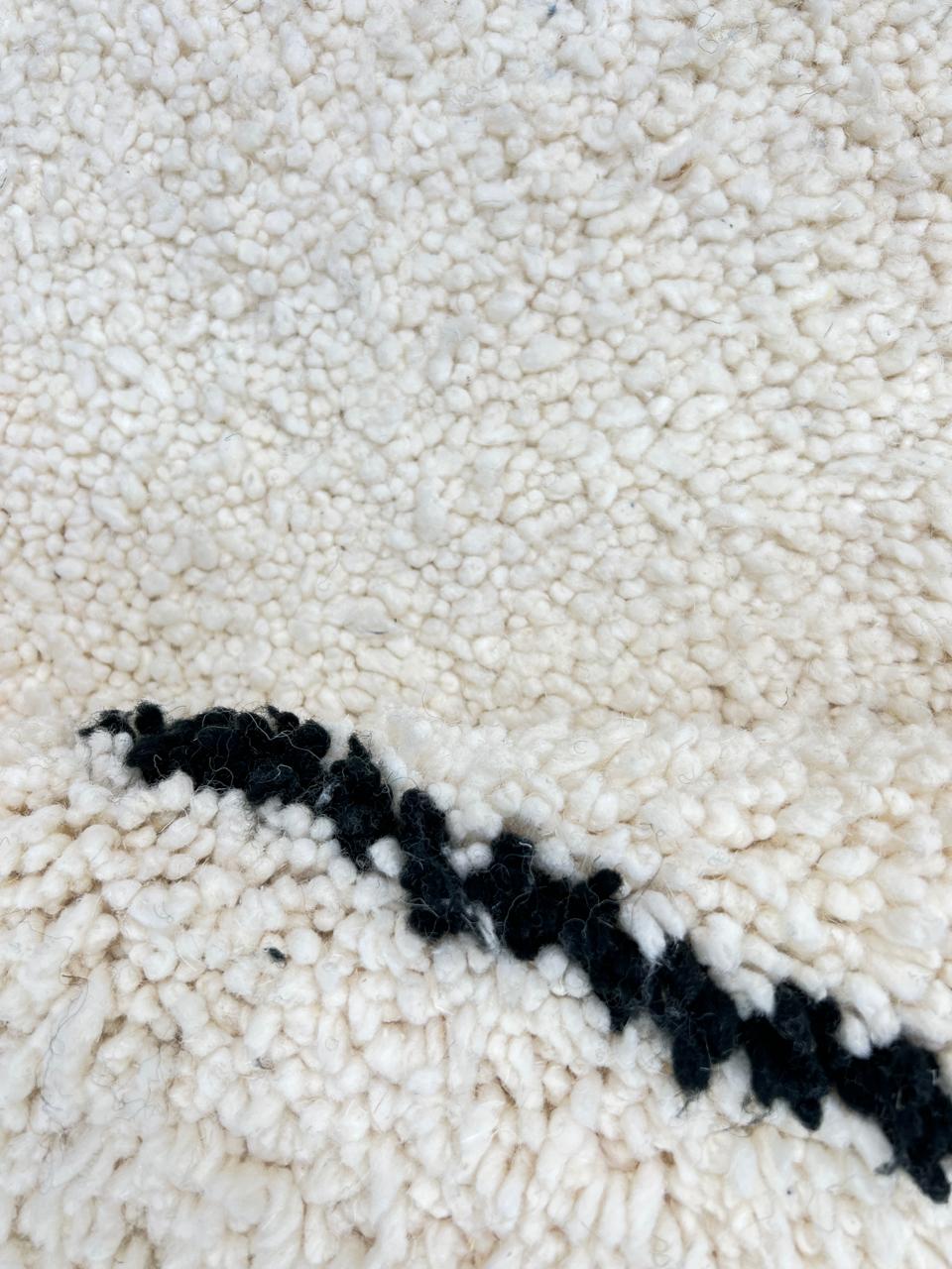 Round Beni Ourain Moroccan rug with white wool base and black diamond pattern, handmade wool carpet