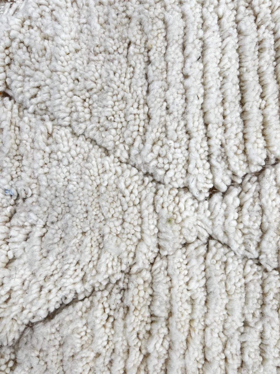 Round Moroccan wool rug with subtle carved diamond pattern, handmade by Berber artisans