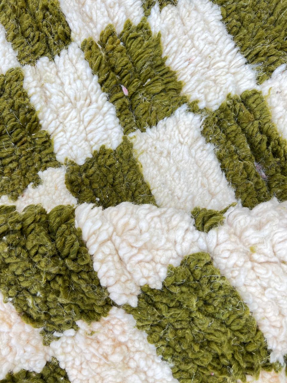 Round Moroccan rug with green and white checkerboard pattern