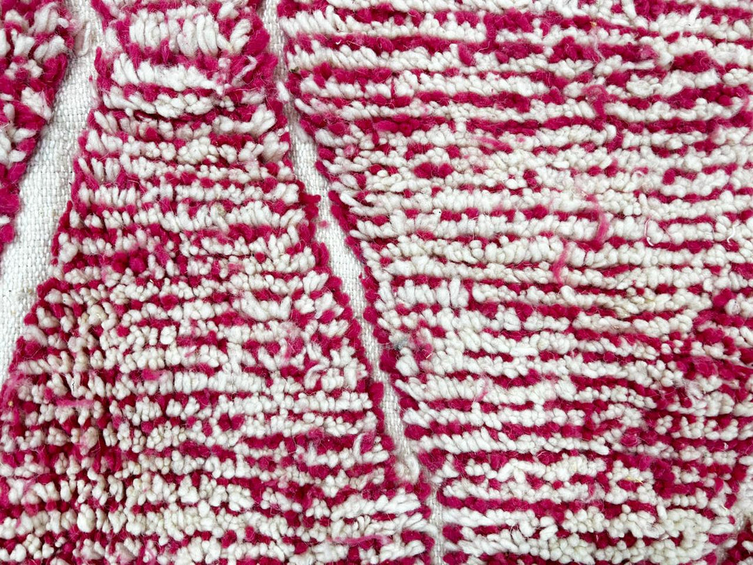 Round pink Moroccan wool rug with white Beni Ourain diamond pattern, handmade by Berber artisans