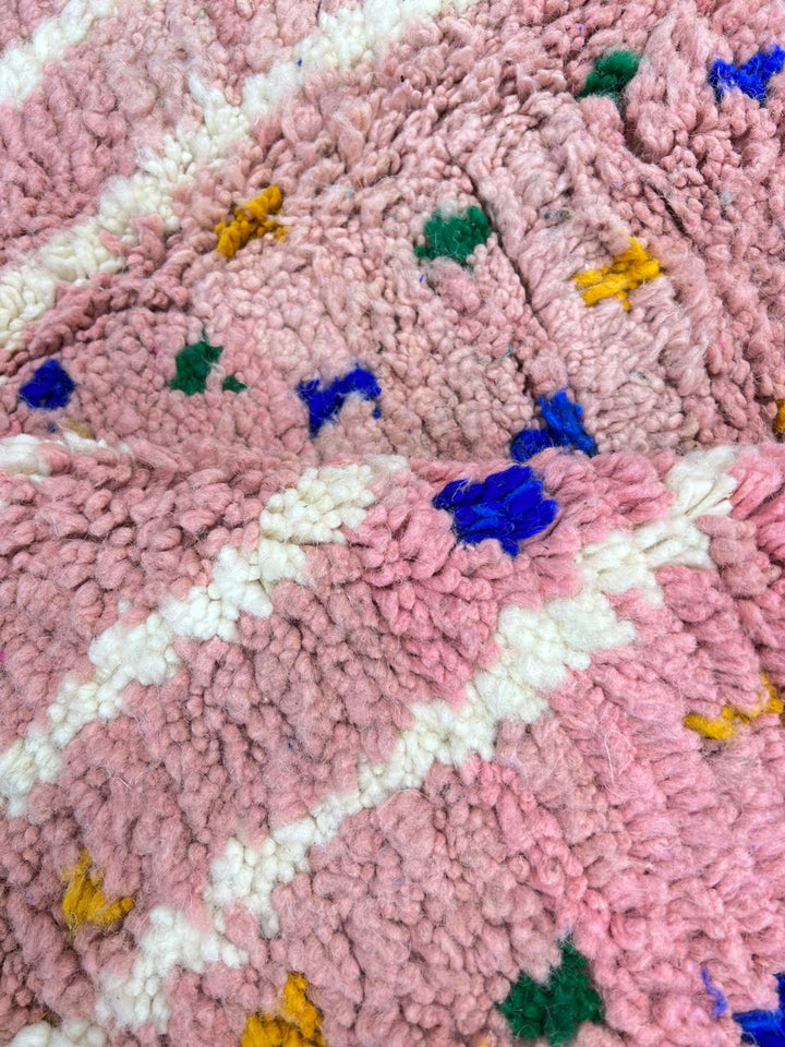 Handmade Moroccan runner rug with vibrant pink background, multicolor dotted accents, and abstract white and blue line design, crafted from natural wool.