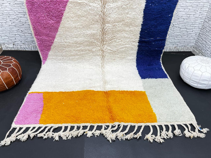 Colorful Moroccan wool rug with pink, blue, and yellow color block abstract design, handmade by Berber artisans