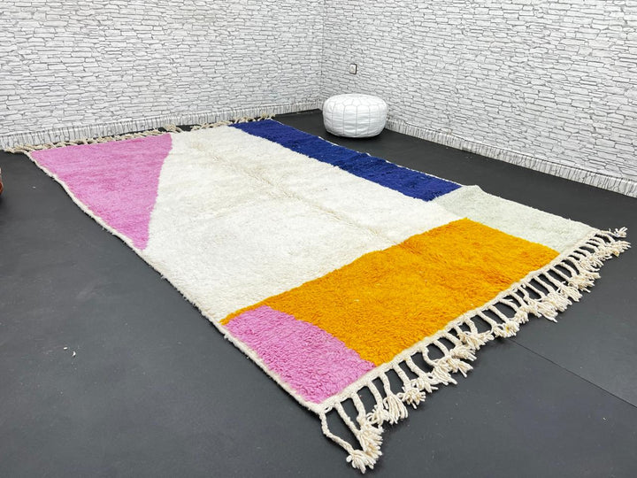 Colorful Moroccan wool rug with pink, blue, and yellow color block abstract design, handmade by Berber artisans