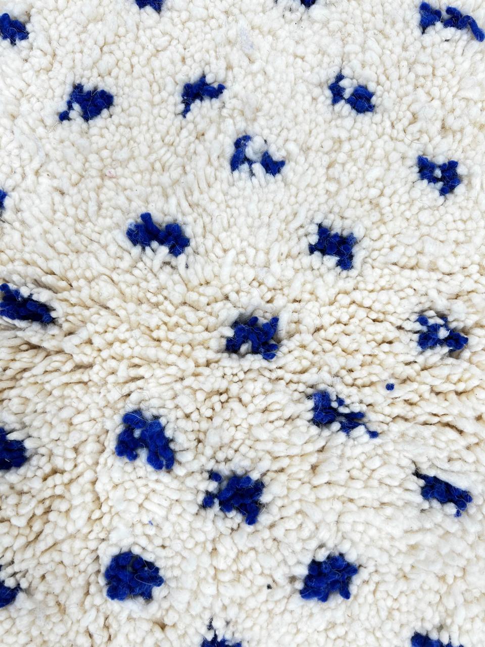 Handmade white Moroccan runner rug with small blue dotted pattern, woven from natural wool by Berber artisans.