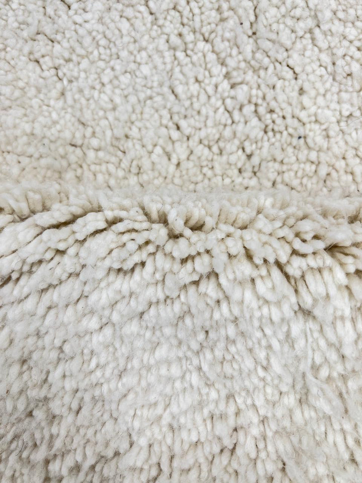 Handmade Moroccan runner rug in solid white natural wool with minimalist tassels, crafted by Berber artisans.