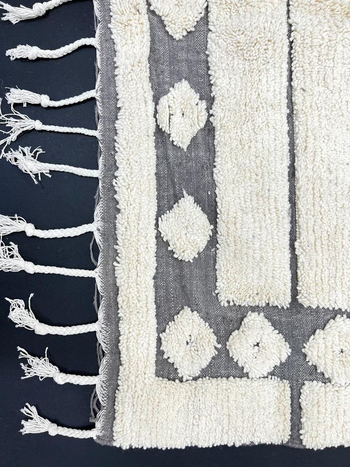 Handmade white Moroccan runner rug with grey tribal border and diamond motifs, Berber wool hallway carpet, minimalist modern Moroccan runner design.