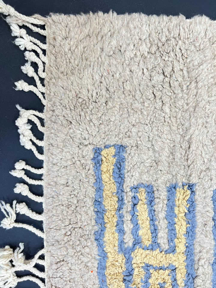 Yellow and blue Moroccan wool rug with geometric Berber border pattern