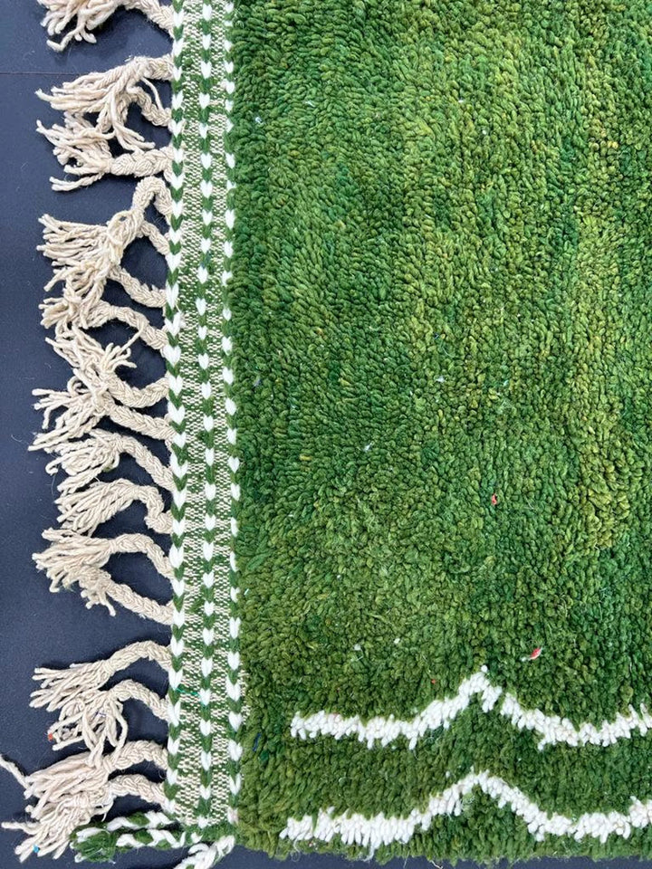 Green Moroccan wool rug with fringes, showing intricate Berber craftsmanship