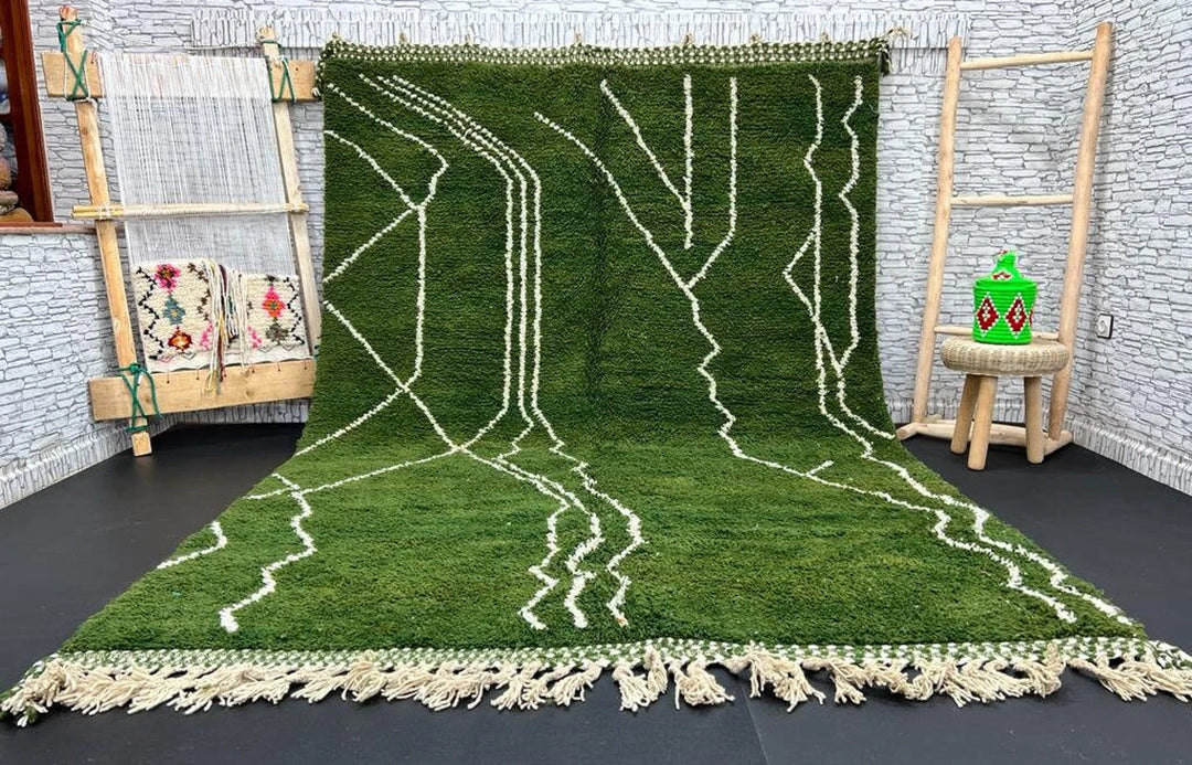 Forest green Moroccan wool rug with white geometric lines, handmade by Berber artisans, displayed in a rustic setting.
